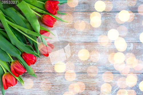 Image of close up of red tulips on wooden background