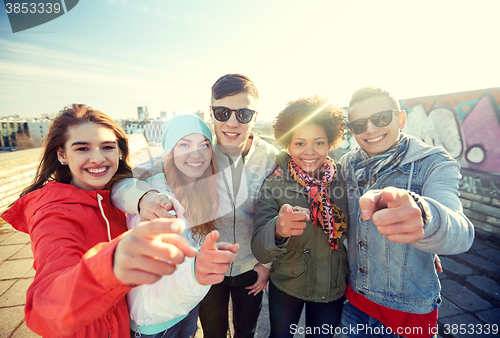 Image of happy teenage friends pointing fingers on street