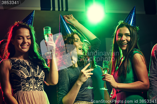 Image of smiling friends with glasses of champagne in club