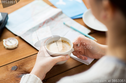 Image of close up of hands with coffee cup and travel stuff