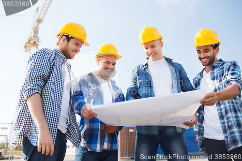 Image of group of builders with tablet pc and blueprint