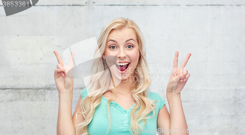 Image of smiling young woman or teenage girl showing peace