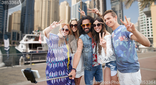 Image of hippie friends with smartphone on selfie stick