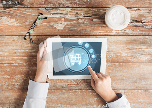 Image of close up of hands with tablet pc and shopping cart