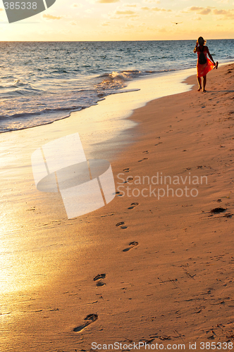 Image of Woman walking on beach