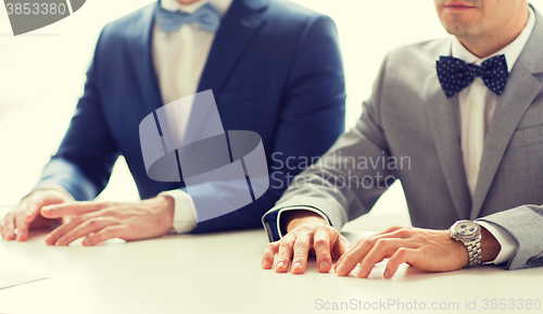 Image of close up of happy male gay couple hands on wedding