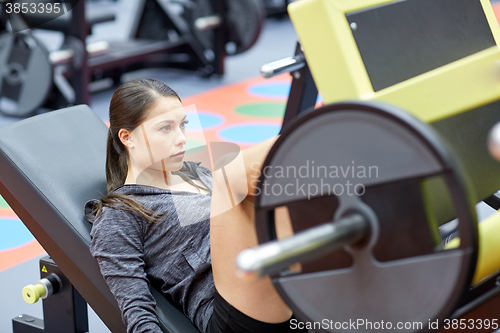 Image of woman flexing muscles on leg press machine in gym