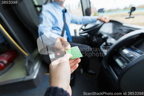 Image of bus driver taking ticket or card from passenger