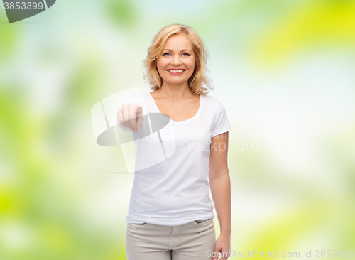 Image of smiling woman in white t-shirt pointing to you