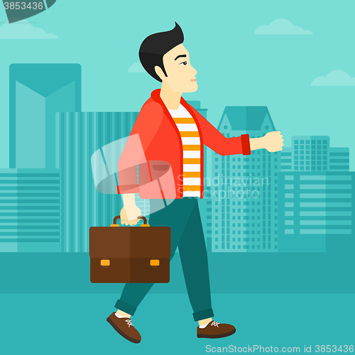 Image of Businessman walking with briefcase. 