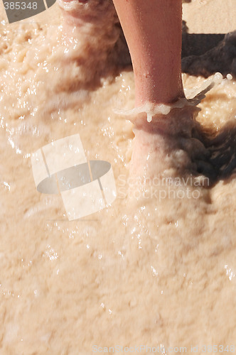 Image of Feet washed in ocean wave