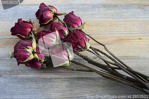 Image of bouquet of withered roses on a wooden