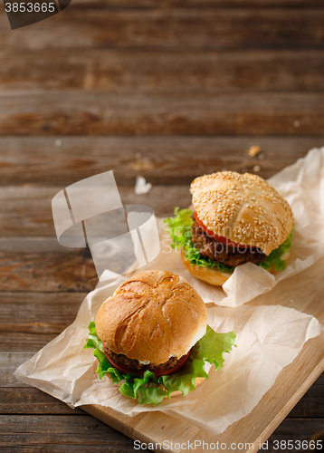 Image of Homemade hamburgers and french fries on wooden table