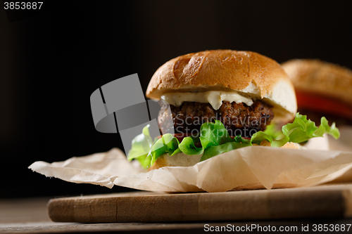 Image of Homemade hamburgers and french fries on wooden table