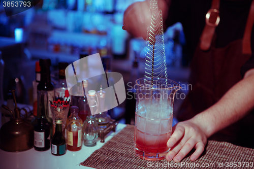 Image of Bartender nixed cocktail in glass cup.