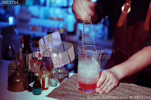 Image of Bartender nixed cocktail in glass cup.