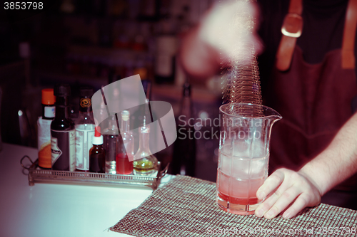 Image of Bartender nixed cocktail in glass cup.