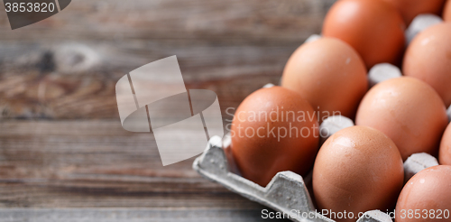 Image of Brown eggs on a rustic wooden table