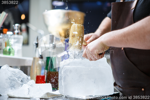 Image of Bartender mannually crushed ice with wooden hammer and metal knife.