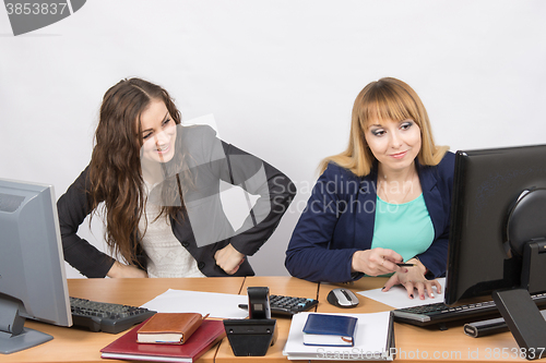 Image of Office worker with feigned indignation looking at the colleague sitting next to the computer innocently