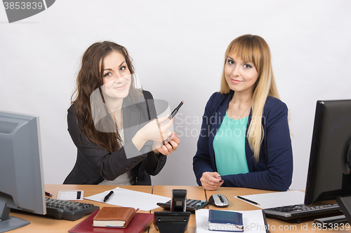 Image of Office girl sitting next to a colleague offers lipstick