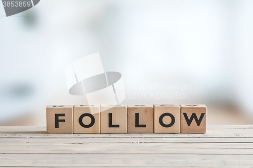 Image of Follow sign on a wooden table