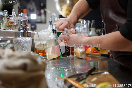 Image of Bartender pours alcoholic drink into small glasses with flames