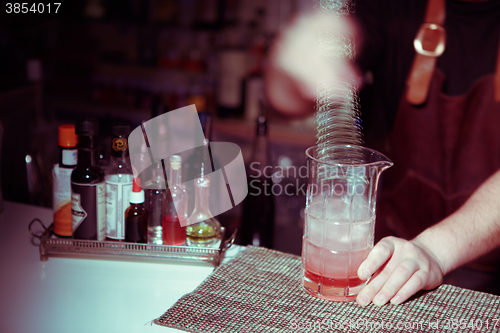 Image of Bartender nixed cocktail in glass cup.