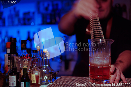 Image of Bartender nixed cocktail in glass cup.