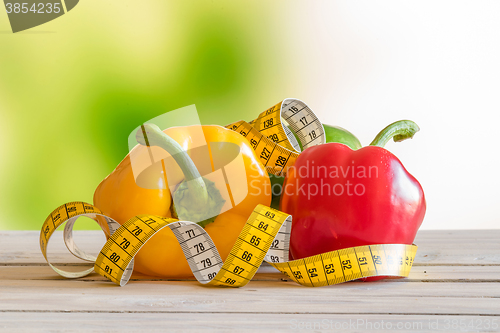 Image of Pepper with measure tape on a wooden table