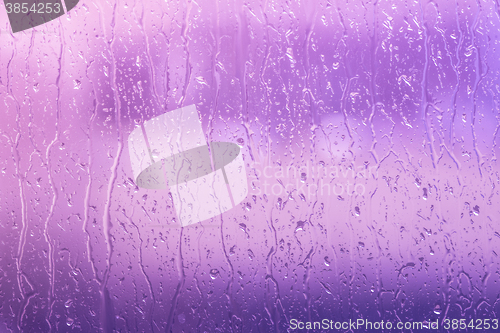 Image of Rain on a window in purple colors