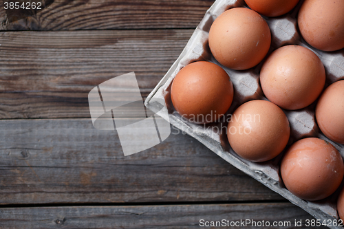 Image of Brown eggs on a rustic wooden table