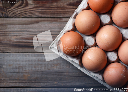 Image of Brown eggs on a rustic wooden table