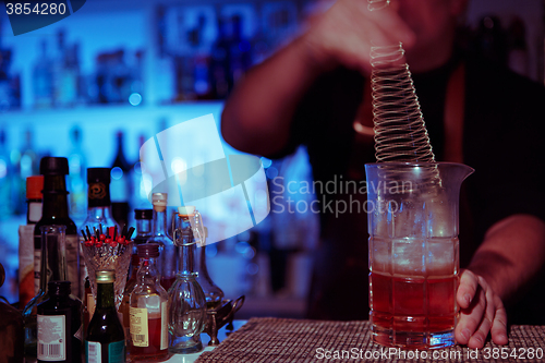 Image of Bartender nixed cocktail in glass cup.