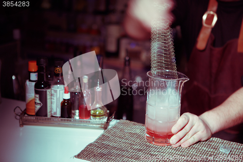 Image of Bartender nixed cocktail in glass cup.