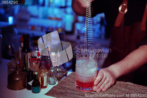 Image of Bartender nixed cocktail in glass cup.