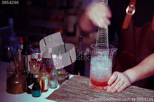 Image of Bartender nixed cocktail in glass cup.