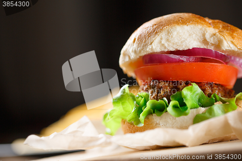 Image of Homemade burger with french fries on wooden table