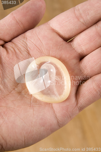 Image of hand holding condom