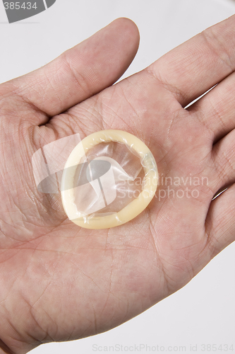 Image of hand holding condom