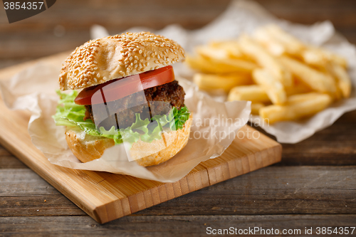 Image of Homemade hamburgers and french fries on wooden table