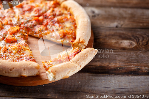 Image of Delicious italian pizza with one eating piece