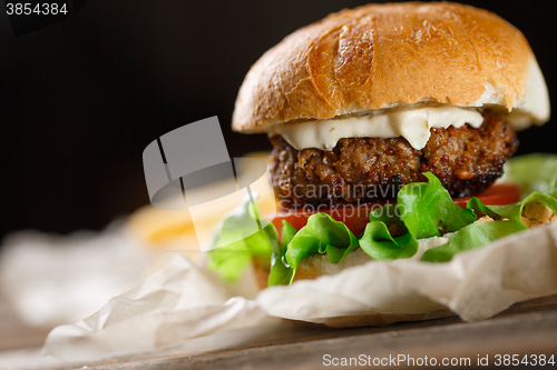 Image of Homemade burger with french fries on wooden table