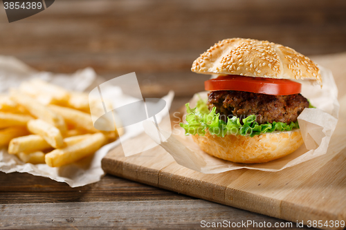 Image of Homemade hamburgers and french fries on wooden table