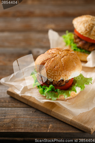 Image of Homemade hamburgers and french fries on wooden table