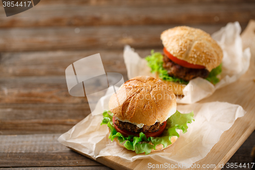 Image of Homemade hamburgers and french fries on wooden table