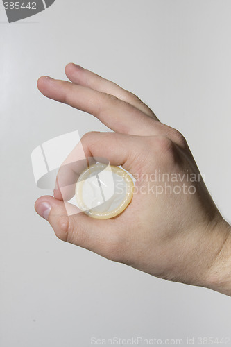 Image of hand holding condom