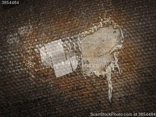 Image of Detail (damage) of an old canvas suitcase, close-up