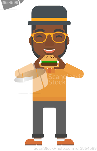 Image of Man eating hamburger. 