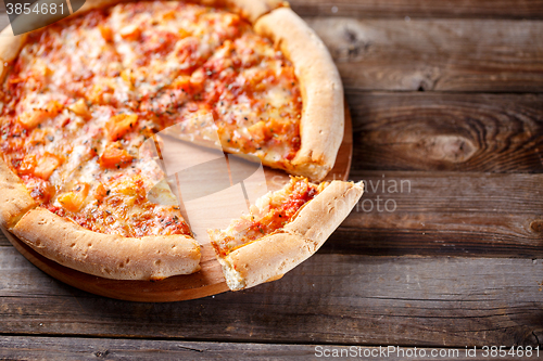 Image of Delicious italian pizza with one eating piece